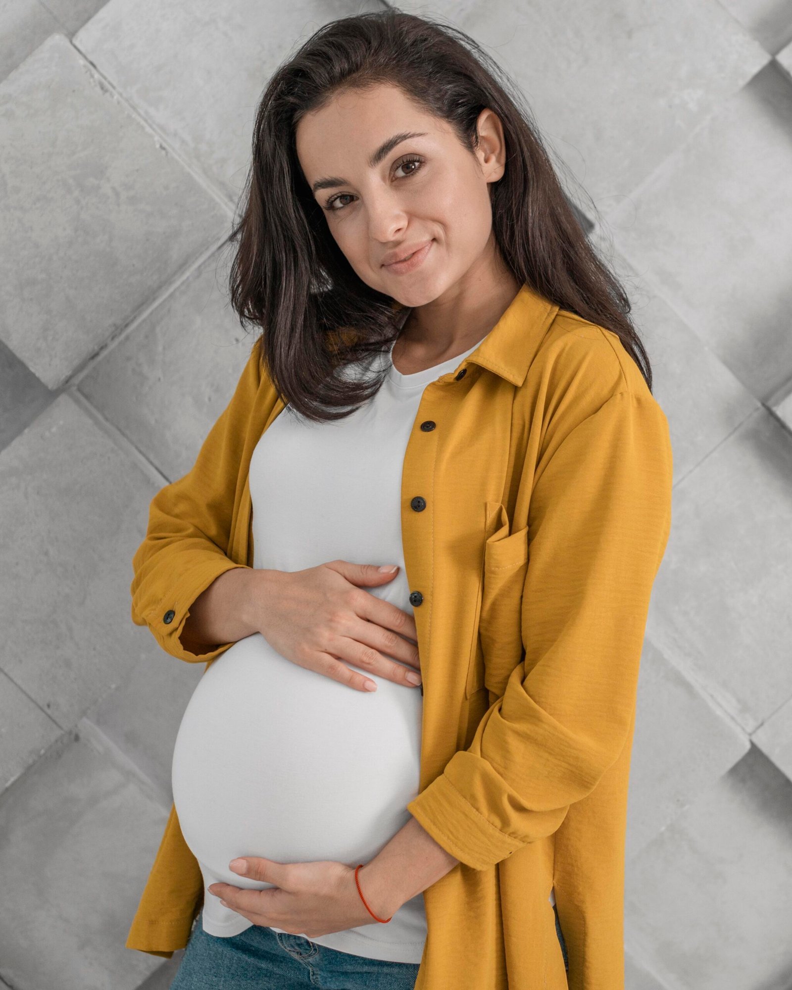 Happy pregnant woman holding belly