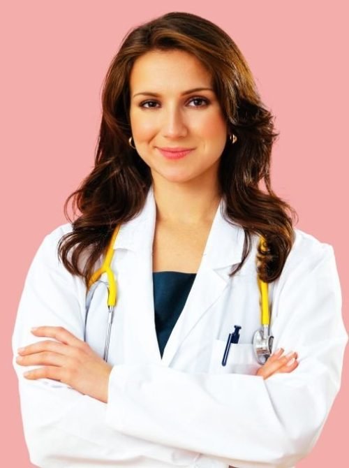 Portrait of confident female doctor with arms crossed on pink studio background health care practitioner